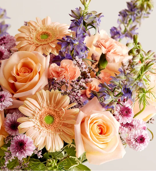 A garden-fresh gathering of blooms in sweet shades of lavender, purple, peach and pink come together for a mix of color and texture