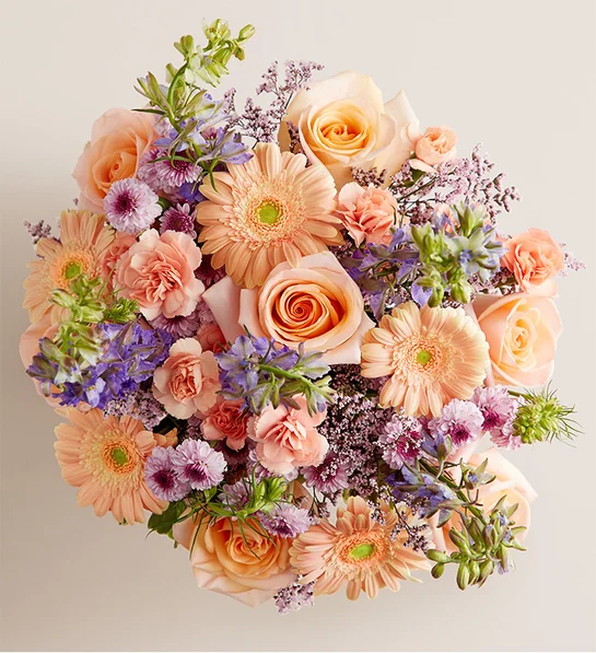 A garden-fresh gathering of blooms in sweet shades of lavender, purple, peach and pink come together for a mix of color and texture