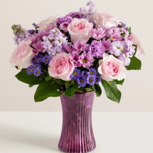 Lavender bouquet is gathered with accents of pink and lush greenery in our striking fluted violet gathering vase for mother's day flowers